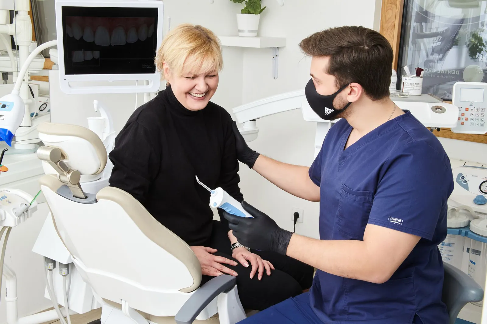 Dentista atendiendo a una paciente en la clínica